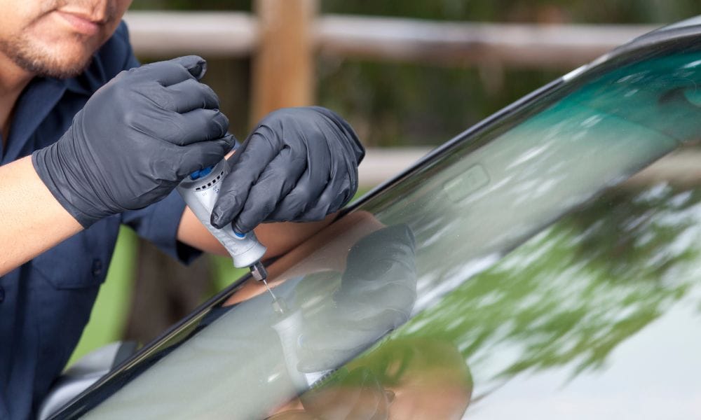 Technician repairing windshield with tool ss collision az